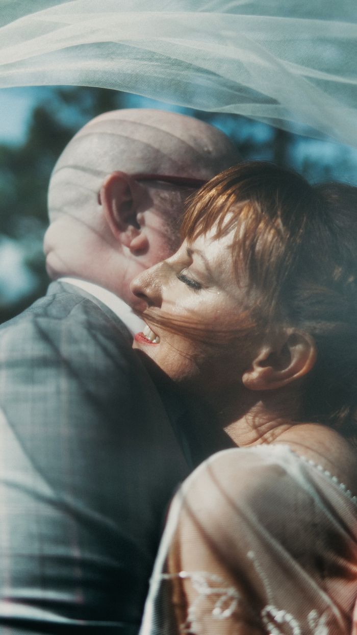 A touching moment between a couple on their wedding day outdoors.